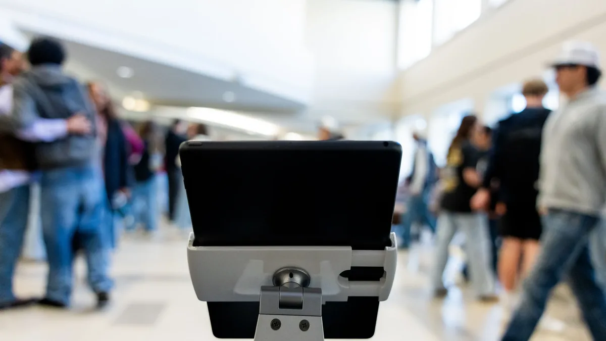 A security camera in a public area, with a crowd of people in the background.